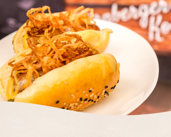 Hotdog gefüllt mit Nürnberger, Gewürzgurken und Röstzwiebel.