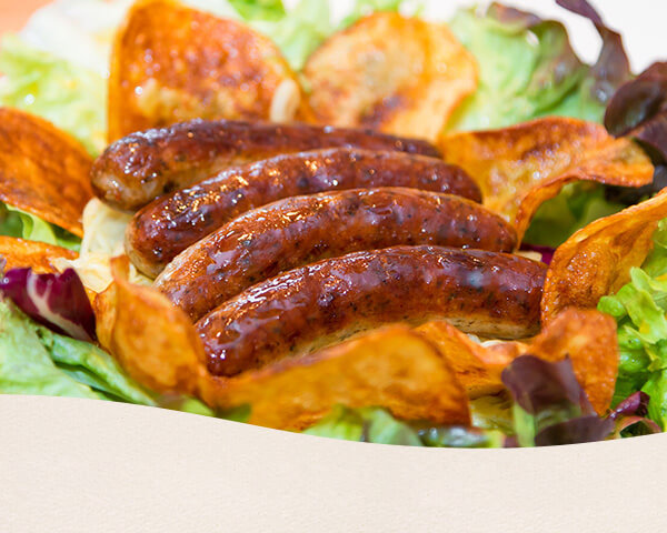 Salat mit Nürnberger Würstchen, Weißkraut und Chips.
