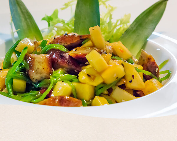 Exotischer Wurstsalat mit Nürnberger Würstchen, Mango und Salat.