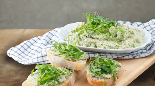 Frühlingsaufstrich mit Rucola und Thüringer Kochschinken garniert auf Baguettebrot