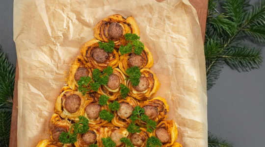 Thüringer Rostbratwürste eingewickelt in Blätterteig und in Tannenbaum-Form auf Backpapier ausgelegt.