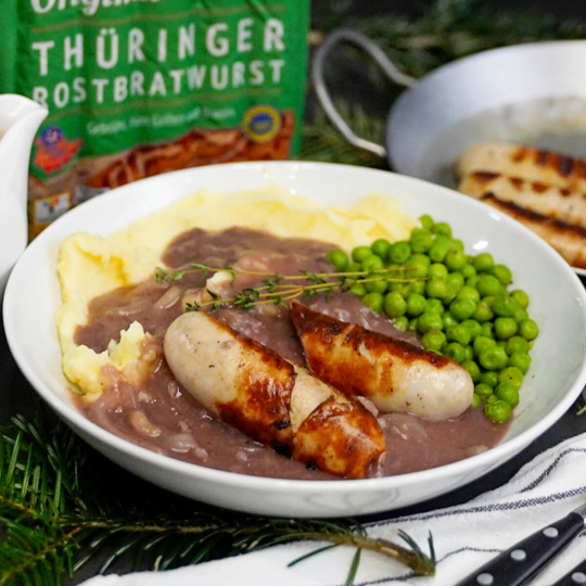 Thüringer Rostbratwürste auf Zwiebelsoße und Kartoffelbrei mit Erbsen