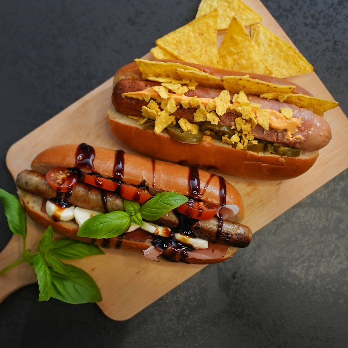 Zwei verschieden belegte Hotdogs. Einer mit Berner Würstchen von Wolf. der andere mit der Original Nürnberger Rostbratwurst von Wolf.