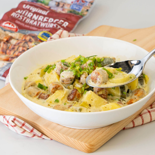 Käse-Lauch-Eintopf mit Original Nürnberger Rostbratwürste verfeinert in einem Teller