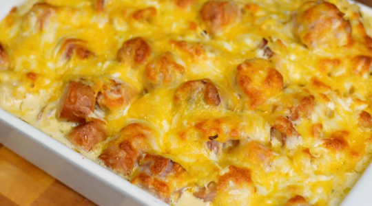 Auflaufform mit Berner Würstchen, Sauerkraut, Soße und Käse überbacken