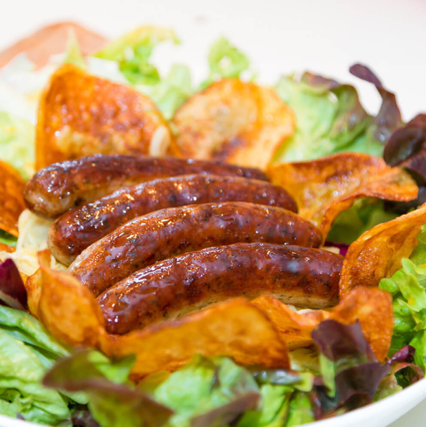 Salat mit Nürnberger Würstchen, Weißkraut und Chips.